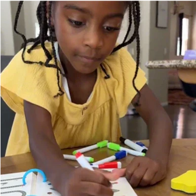 Girl practicing writing over notebook
